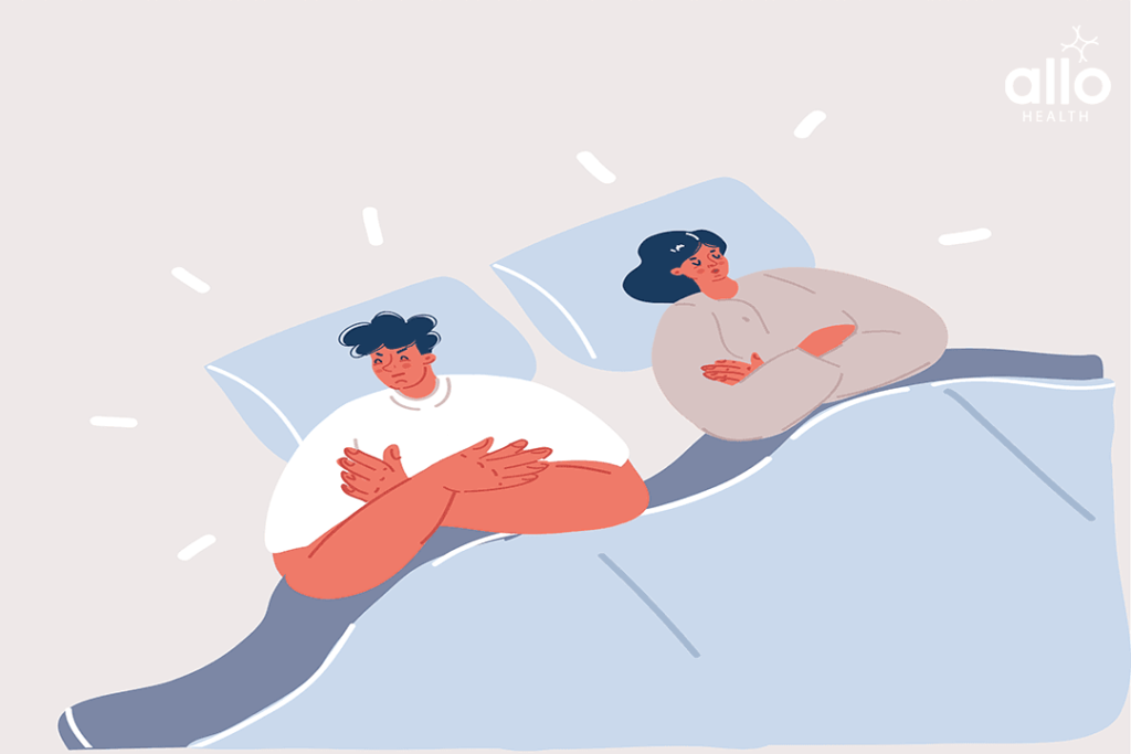 Upset couple having marital problems or a disagreement lying side by side in bed facing in opposite directions ignoring one another. Wife and husband together in bad