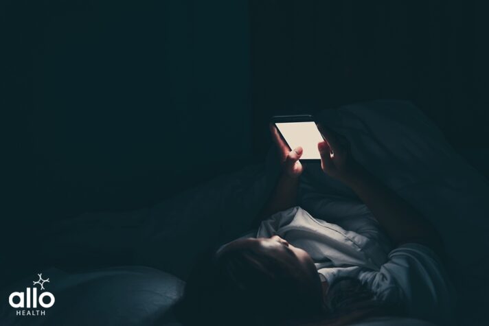 woman watching porn on smartphone in the bed at night