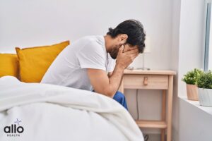 man sitting on bed and suffering with the Delayed Ejaculation Symptoms