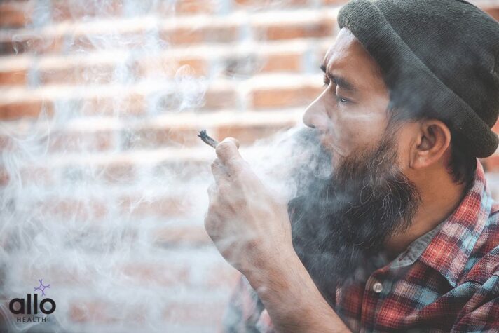 closed up mustache man smoke Cannabis joint