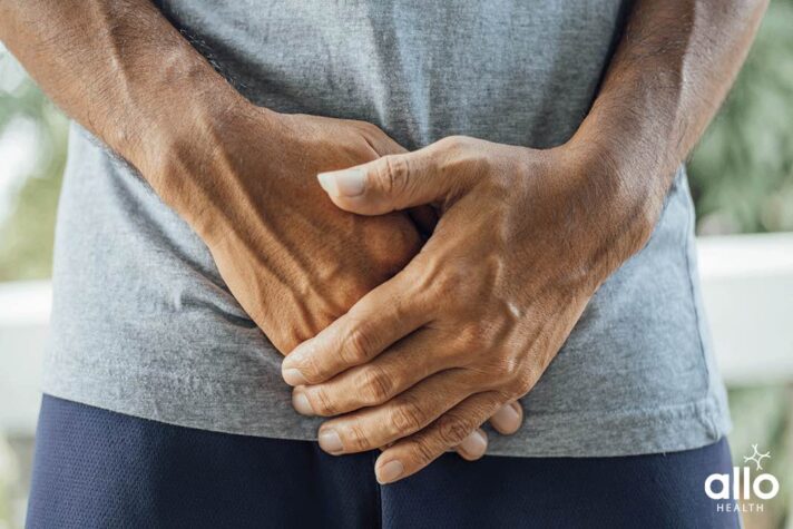 man suffering with Urinary Tract Infection and holding lower abdomen due to pain, prevention of gonorrhea in hindi