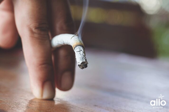 half smoked cigarette and a hand holding it, does smoking stop you from ejaculating