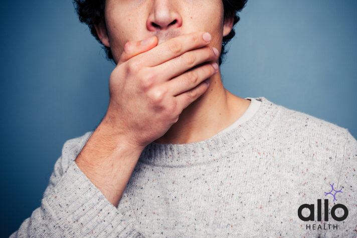 Shocked young man with his hand on his mouth after hearing the effects of Fusidic Acid on Sexual Health