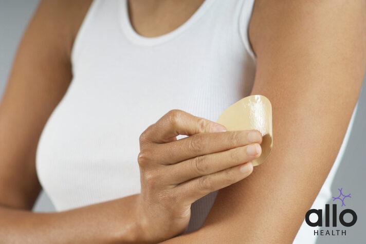 Woman applying Nicotine patch to arm