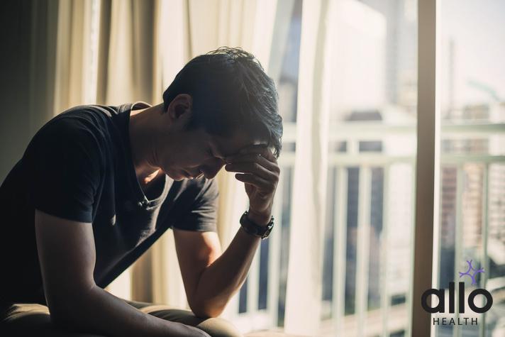 Sad man lying on the floor full of desperation thoughts .Portrait of thoughtful sad man alone. Fear, sadness, abuse, depression, addiction. sad man with a hand on the head sitting on a couch in the living room at home. ling ki samasya. ling khada hone ka tablet